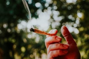 hand holding a lit joint outside