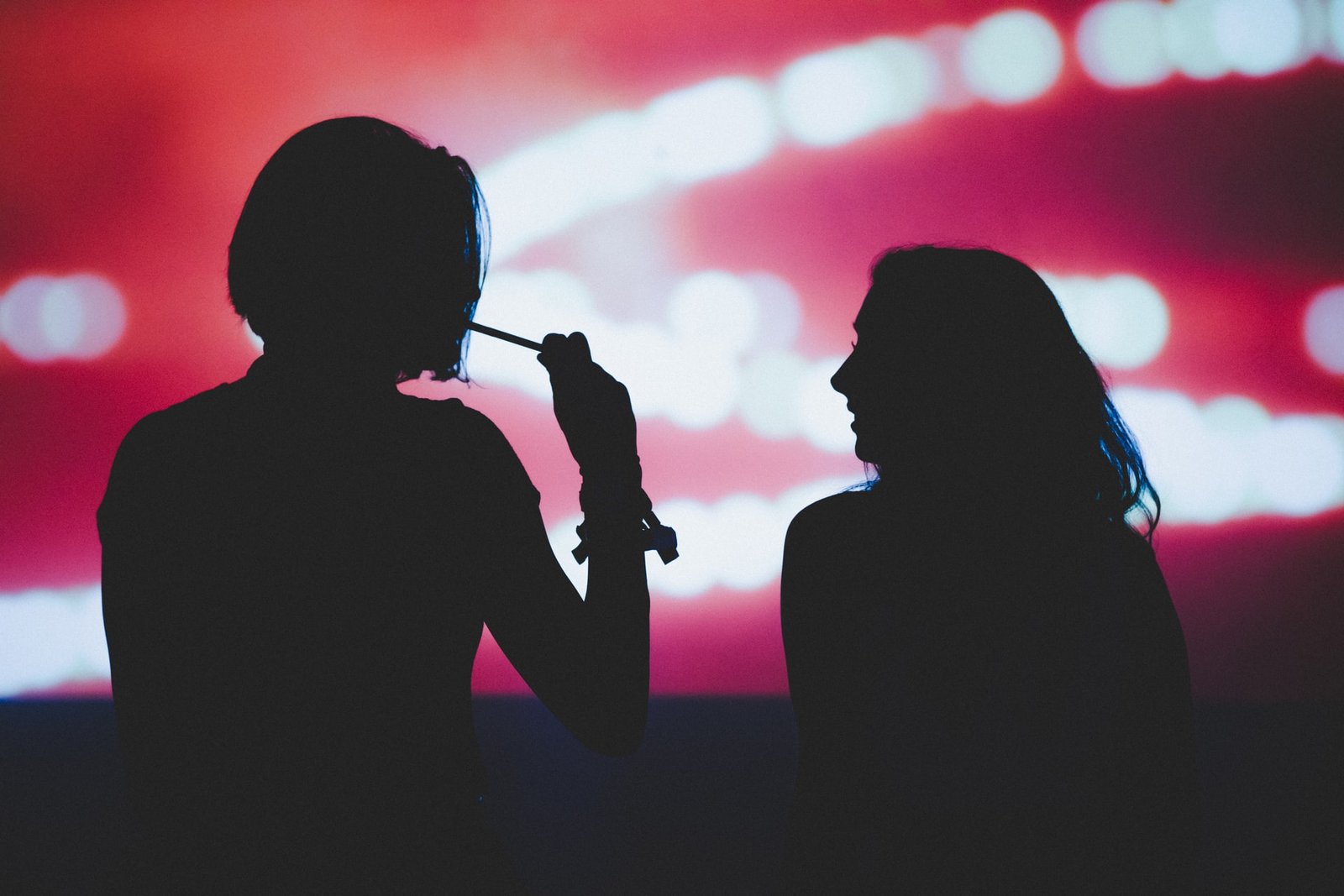 silhouette of two people smoking weed
