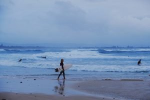 surfer walking to ocean in Byron Bay