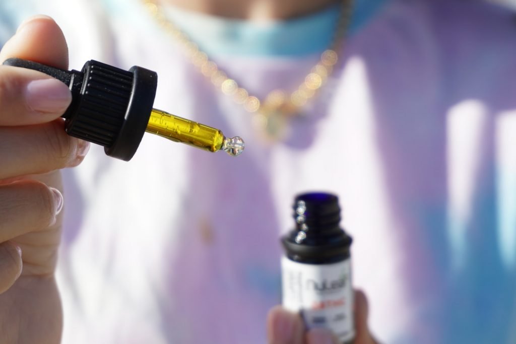 close up of someone holding CBD oil bottle