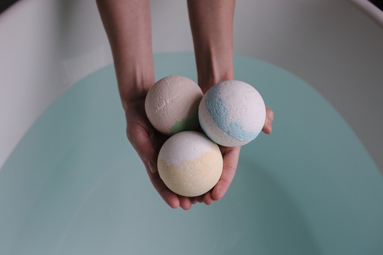 hand holding out three bath bombs