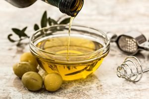 olive oil being poured into small glass bowl