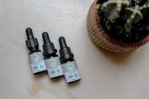 three small bottles of CBD oil on table